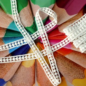 Offwhite Baumwollspitze 16mm mit runden Noppen auf farbigem Untergrund. 3m weiches, unelastisches Spitzenband für kreative DIY-Nähprojekte.