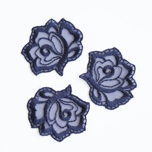 Blumen-Applikation dunkelblau auf weissem Hintergrund. Filigrane, 5x6cm grosse Tüllstickerei-Spitze mit detaillierter Stickerei auf passendem Mesh-Stoff.