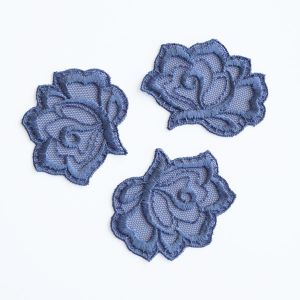 Blumen-Applikation jeansblau auf weissem Hintergrund. Filigrane, 5x6cm grosse Tüllstickerei-Spitze mit detaillierter Stickerei auf passendem Mesh-Stoff.