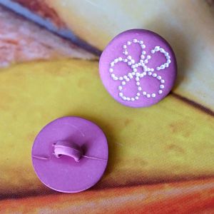 Zwei matte, mauvefarbene Blumenkn&ouml;pfe (15mm) aus Kunststoff, einer zeigt das weisse Blumenmotiv, der andere die angen&auml;hte &Ouml;se auf der R&uuml;ckseite bei Spitzentraum.ch.