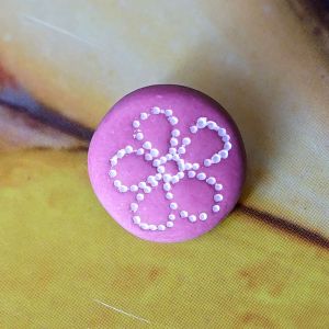 Runder, matter &Ouml;senknopf (15mm) in der Farbe Mauve mit einer aufgedruckten weissen Blume aus feinen Punkten, Nahaufnahme bei Spitzentraum.ch.