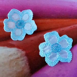 Zwei elegante Satin-Blumen zum Aufb&uuml;geln in aqua mit irisierendem Schimmer aus der N&auml;he fotografiert