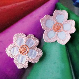 Zwei elegante Satin-Blumen zum Aufb&uuml;geln in lachs mit irisierendem Schimmer aus der N&auml;he fotografiert