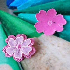 Vorder- und R&uuml;ckseite der rosa-pinken 3D-Satinblume zum Aufb&uuml;geln f&uuml;r Kleidung und DIY.