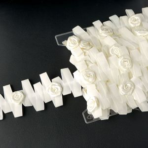 Detailansicht eines ecrufarbigen Dekobandes in Zickzack-Form, verziert mit 3cm grossen Satinrosen auf aufgereihten Farbstiften bei Spitzentraum.ch.