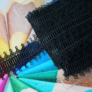 Hochwertige schwarze Guipure-Spitze (5 cm) aufgewickelt auf K&auml;rtchen mit bunter Stifte-Unterlage gezeigt online bei Spitzentraum.ch bestellen.