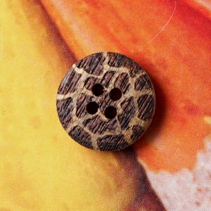 Nahaufnahme eines 18mm Holzknopfes mit 4 L&ouml;chern und einem durch Lasergravur erzeugten Animalprint im Giraffen-Design f&uuml;r Spitzentraum.ch.