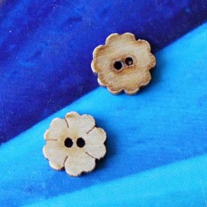 Zwei kleine 10mm Holzkn&ouml;pfe als vierbl&auml;ttrige Kleebl&auml;tter mit dunkler Brandkante zur Ansicht von Vorder- und R&uuml;ckseite bei Spitzentraum.ch.