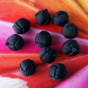 Zehn kugelf&ouml;rmige Kn&auml;uelkn&ouml;pfe in der Farbe Schwarz. Die Oberfl&auml;che aus feiner Satinkordel imitiert die Wicklung eines Wollkn&auml;uels und verleiht eine tolle Haptik.