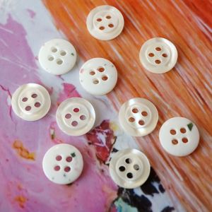11mm Knöpfe in Offwhite, glänzende Epoxid-Vorderseite, 4-Loch, eingesenkte Mitte. Rückseite abgerundet mit bunten Konfetti-Punkten. Set für Blusen und Hemden.