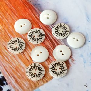 15mm Kunststoffknöpfe in Offwhite mit schwarzem grafischem Sonnen-Muster, 2-Loch, glatte Oberfläche. Perfekt für Blusen, Hemden und Kinderkleidung.