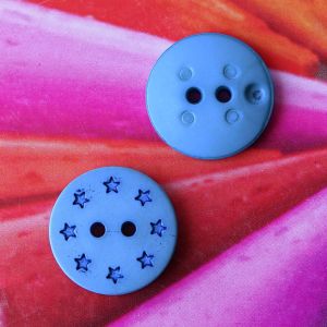 Zwei blaue Sternenkn&ouml;pfe (12mm) zur Ansicht der gemusterten Vorderseite und der glatten R&uuml;ckseite mit den zwei N&auml;hl&ouml;chern bei Spitzentraum.ch.