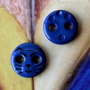 Zwei dunkelblaue Katzenkn&ouml;pfe (12mm) aus Kunststoff zur Ansicht der Vorderseite mit dem schwarzen Tiermotiv und der leicht strukturierten, glatten R&uuml;ckseite.