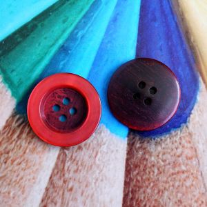 Roter 20mm Kunststoffknopf mit Kunstharz-Schimmer. Ansicht der gl&auml;nzenden Vorderseite und der R&uuml;ckseite mit 4 L&ouml;chern. Stabiler Knopf bei Spitzentraum.ch.