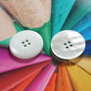 Vergleich der Vorder- und R&uuml;ckseite des 50mm grossen Mantelknopfs in Ecru zur Verdeutlichung der leicht konkaven W&ouml;lbung bei Spitzentraum.ch.