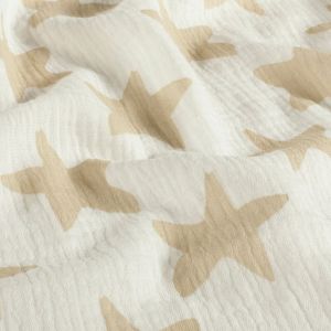 Nahaufnahme des weichen Musselin Stoffes in Offwhite mit Taupe Sternen. Weicher Faltenwurf der feinen, nicht elastischen Baumwolle.