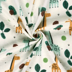 Musselin Stoff mit Giraffen in Ocker und Mint, spiralf&ouml;rmig drapiert. Weicher Faltenwurf der feinen, nicht elastischen Baumwolle f&uuml;r Kinderkleidung.