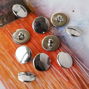 Silberne 13mm Ösenknöpfe, spiegelglatte und leicht abgerundete Oberfläche, stabile Öse auf der Rückseite. Ideal für festliche Blusen und elegante Accessoires.