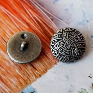 Vorder- und Rückseite eines 18mm Ösenknopfs im Kelten-Stil. Grauer Kunststoff mit dunkelgrauer Patina und stabiler Öse. Ideal für historische Kostüme und Cosplay.