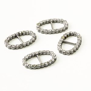 Vier ovale silberne Metall-Schieber (8mm Durchlass) mit funkelnden, farblosen Strasssteinen besetzt auf hellem Untergrund f&uuml;r Spitzentraum.ch.