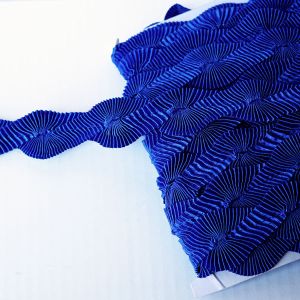 Elastische Plissee-Borte (33mm) in K&ouml;nigsblau aus zwei ineinander gefalteten R&uuml;schenb&auml;ndern mit wellenf&ouml;rmigem F&auml;chermuster gewickelt auf Spitzentraum.ch.