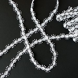 17mm breite Posamentenborte in Weiss mit schwarzer Kante mit wirbelförmigem Muster (3m-Packung) als elegante Zierborte präsentiert auf Spitzentraum.ch.