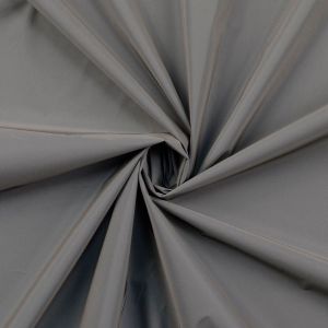 Nahaufnahme des reflektierenden Stoffs, der das Licht stark zurückwirft. Die glatte, silberne Oberfläche und die hochwertige Beschichtung sind deutlich zu erkennen.