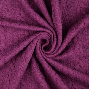 Romanit Strickstoff in der Farbe aubergine mit Feinstrick-Struktur. Detailaufnahme des plastischen Zopfmusters.