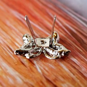 Silberne Schmetterling Zierniete mit Biegestiften und Strass. Ansicht von vorne sowie R&uuml;ckseite mit zwei Metallstiften zum Umbiegen auf Stoff oder Leder.