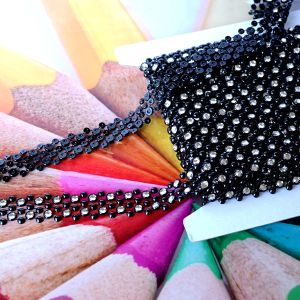 Strass-Dekoband (2cm) in Schwarz-Crystal zur Ansicht der glitzernden Vorderseite und der flachen, flexiblen Kunststoff-R&uuml;ckseite bei Spitzentraum.ch.