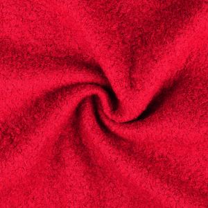 Nahaufnahme von einem schweren Woll-Bouclé Stoff in der Farbe erdbeerrot, mit der charakteristischen lockigen Oberfläche aus vielen kleinen Schlingen.