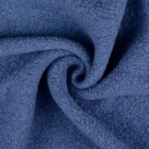Nahaufnahme von einem schweren Woll-Bouclé Stoff in der Farbe jeansblau, mit der charakteristischen lockigen Oberfläche aus vielen kleinen Schlingen.